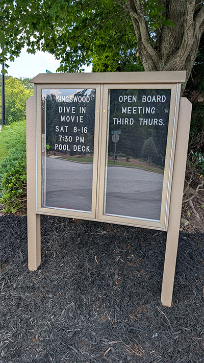 Outdoor HOA community bulletin board with Kingswood event and meeting announcements in Georgia subdivision.