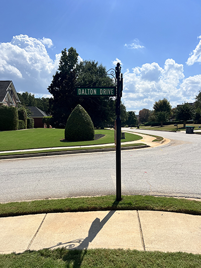 Black decorative street sign post with “Dalton Drive” blade in a manicured Metro Atlanta neighborhood.