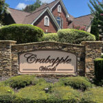 ABOUT Stone monument entrance sign with Crabapple Woods community name in script lettering at a Milton Georgia neighborhood.