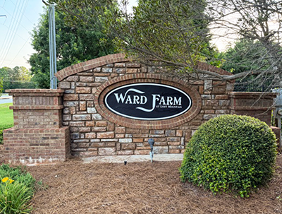Power washed, cleaned, and repainted Ward Farm neighborhood entrance monument sign with stone and brick masonry in Powder Springs, GA.